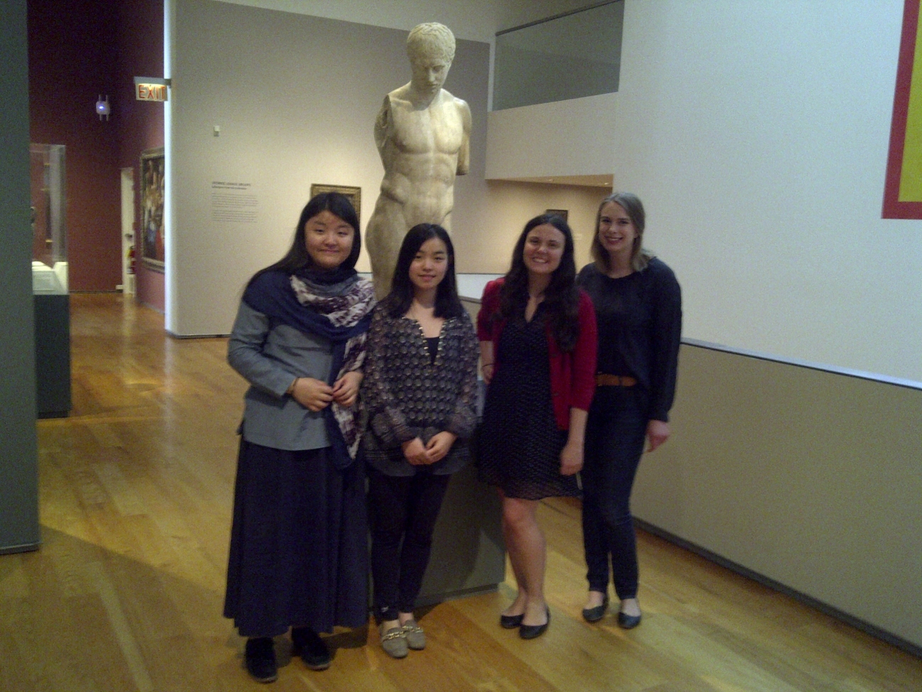 4 students standing in front of armless statue in museum