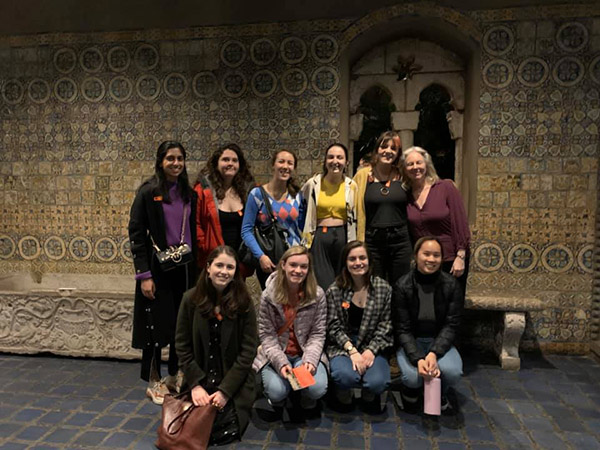students and professor in front of richly patterned wall at the Gardner Museum