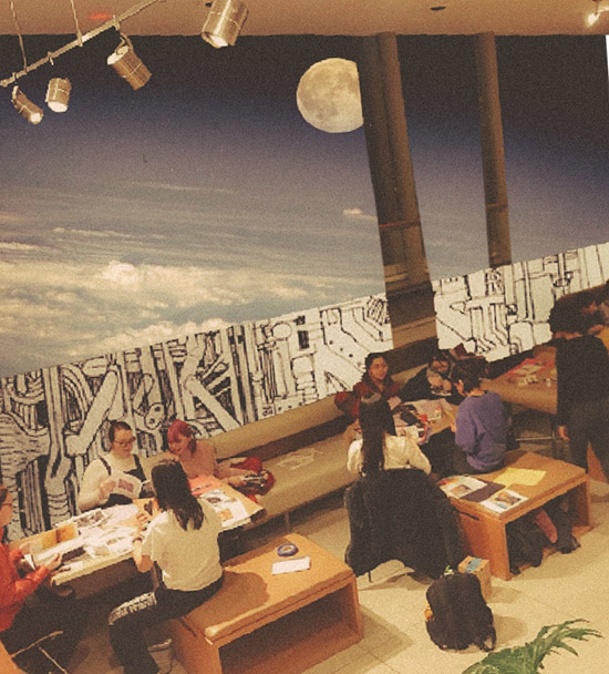 students at tables during art club event, with sky and mural collaged into the background behind them