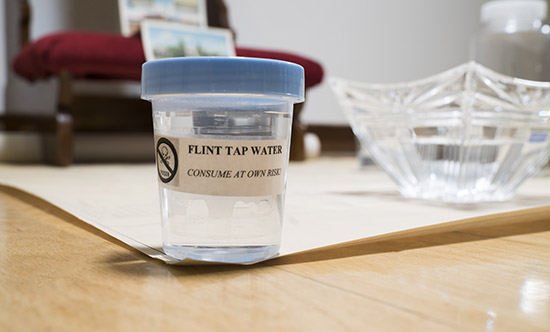 close up on sample container labeled 'FLINT TAP WATER/CONSUME AT OWN RISK'