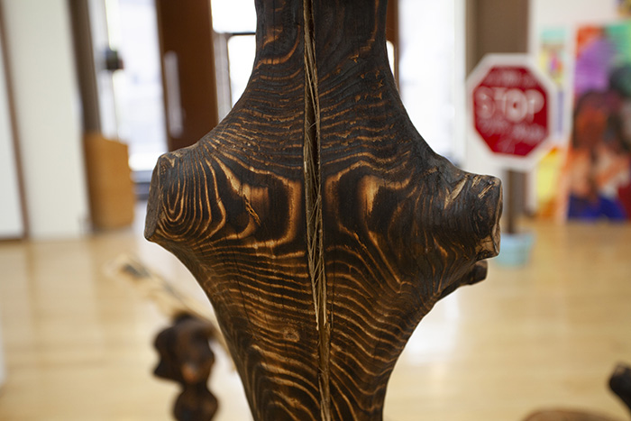 close-up on a stained and carved piece of wood with a large split in the center of the form