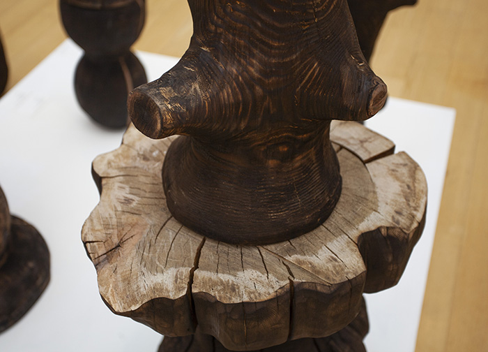 image of a stained and carved wood form sitting on top of a separate stained and carved wood stool
