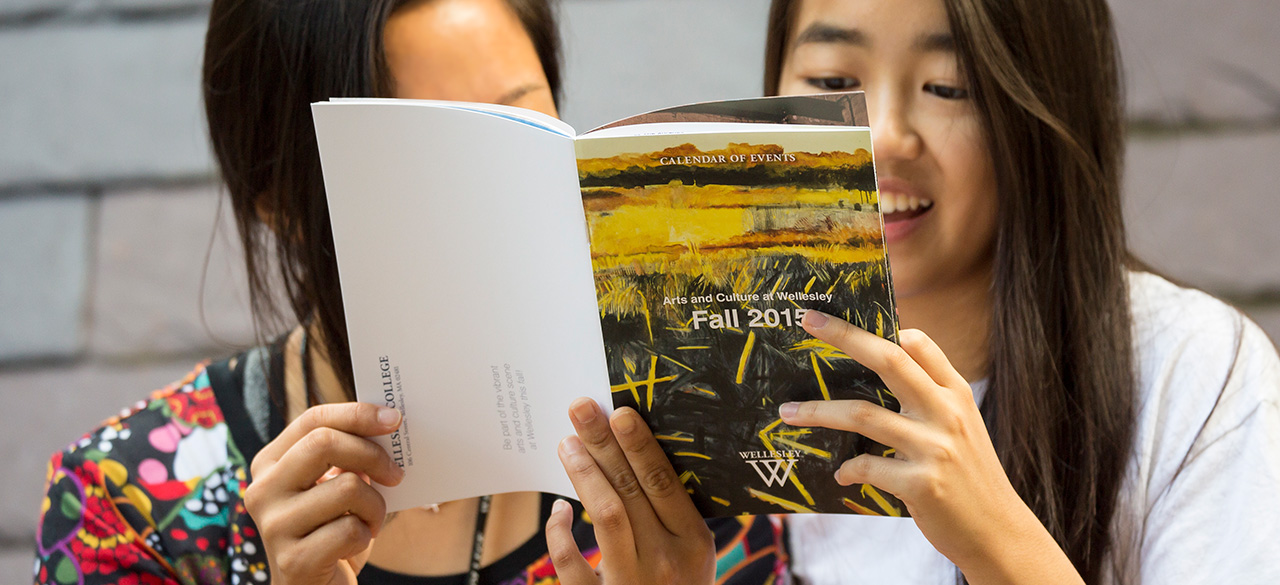 Students read the Fall 2015 Arts Calendar