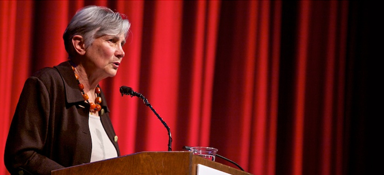 Diane Ravitch ’60 speaking on stage in front of a red curtain