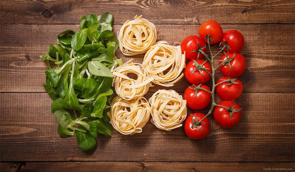 Basil leaves, pasta and tomatoes arranged to represent the Italian flag. 