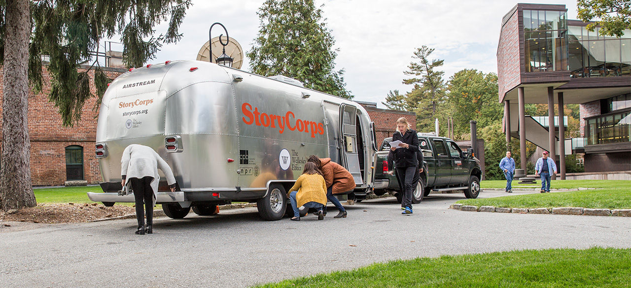 A silver airstream trailer, the StoryCorps MobileBooth, parked near the Wellelsey student center