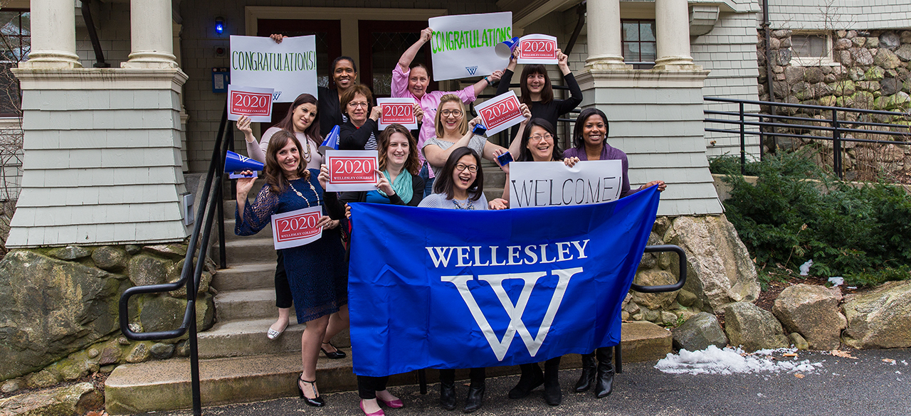 The Admission Office team holds signs welcoming newly-admitted students.