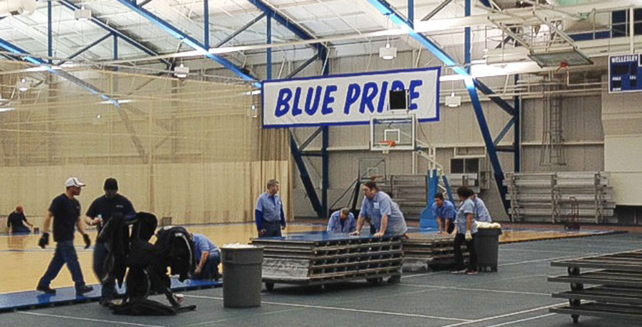 workers remove and stack panels from basketball floor