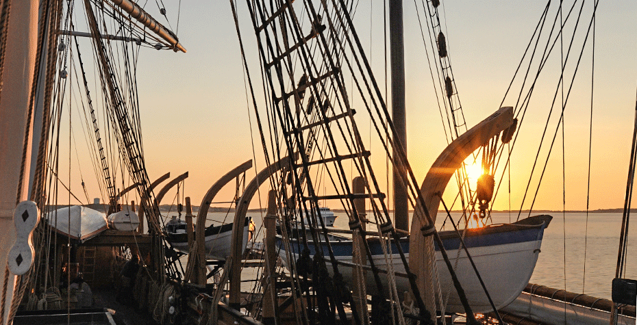 sunrise behing rigging of whaling ship Charles W. Morgan