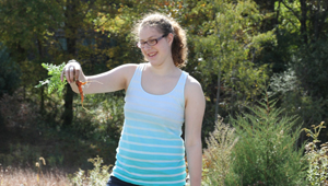 Student shows off carrot harvest