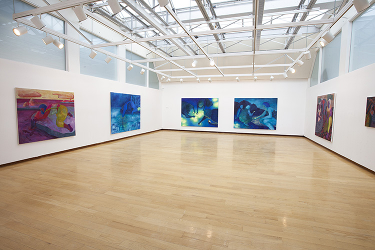 white-walled gallery with wood floor and large, colorful, figurative paintings on the walls