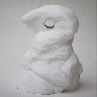white plaster sculpture with hole in the top on white backdrop