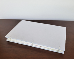 handmade book with white covers on dark desk