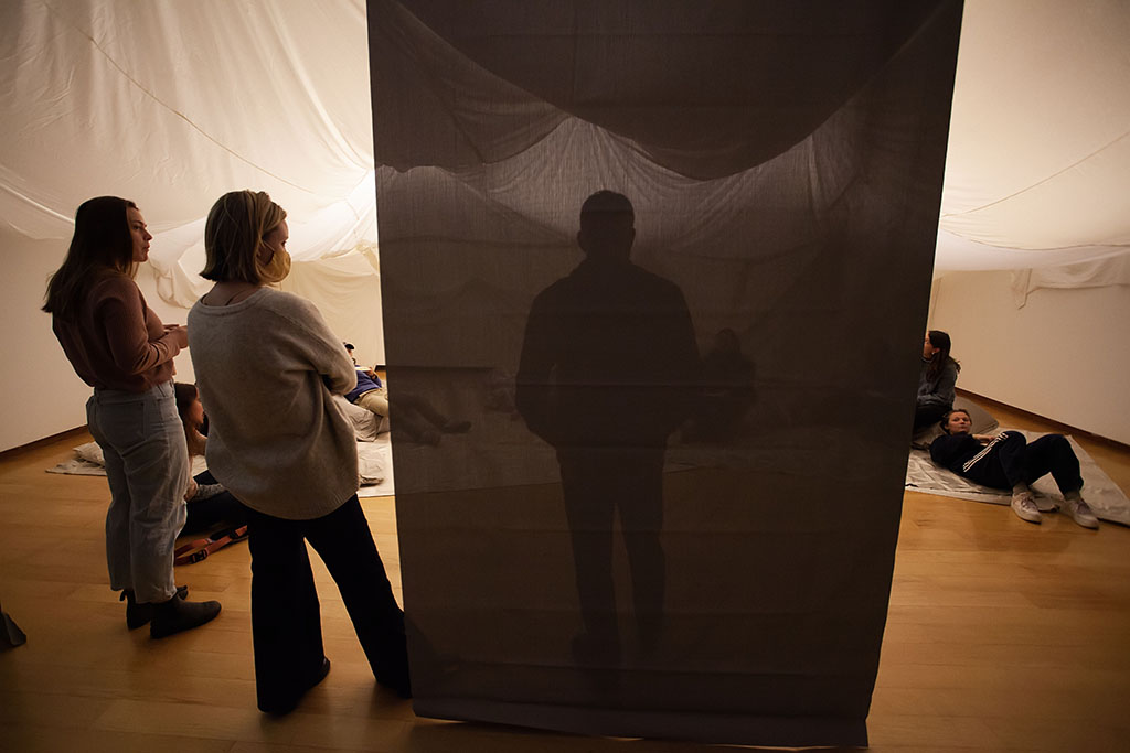 translucent hanging fabric panel with a silhouetted person behind it