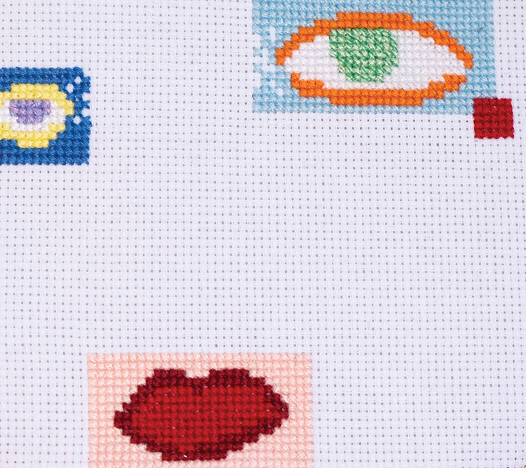 close up of pixelated-looking embroidered eyes and mouth