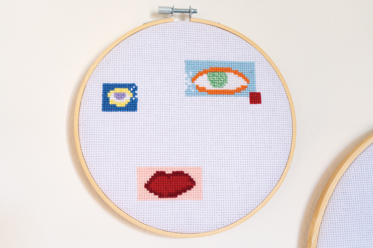 embroidery hoop with squared off, brightly colored eyes and mouth design