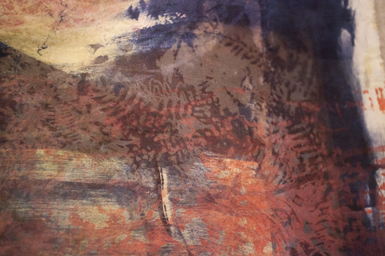 close up on a piece of fabric printed with abstracty and botanical forms in shades of pink and blue