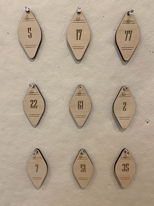 diamond-shaped pale wood key fobs with numbers laser cut into them