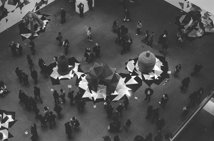black and white photo of sculptural installation with patrons seen from above