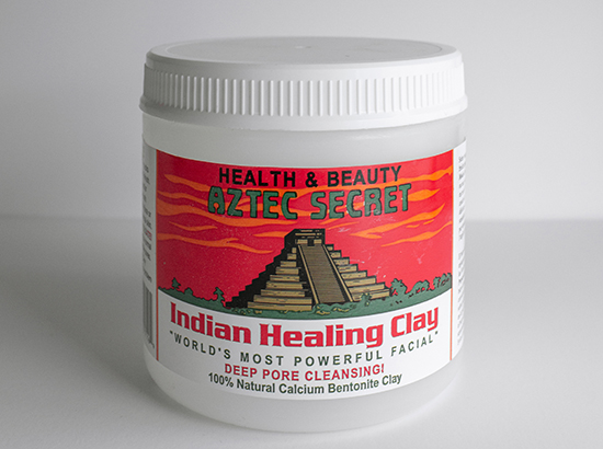 plastic tub with Mesoamerican pyramid on red sky background; label text reads HEALTH & BEAUTY AZTEC SECRET above and INDIAN HEALING CLAY below