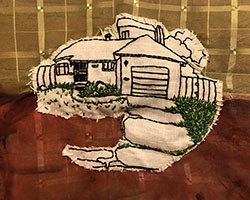white fabric patch with black embroidery making a line drawing of a house, with dense green embroidered lawn