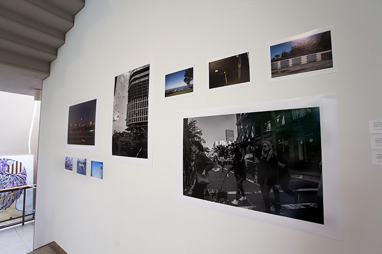 angled view of variously sized photographs on a white wall