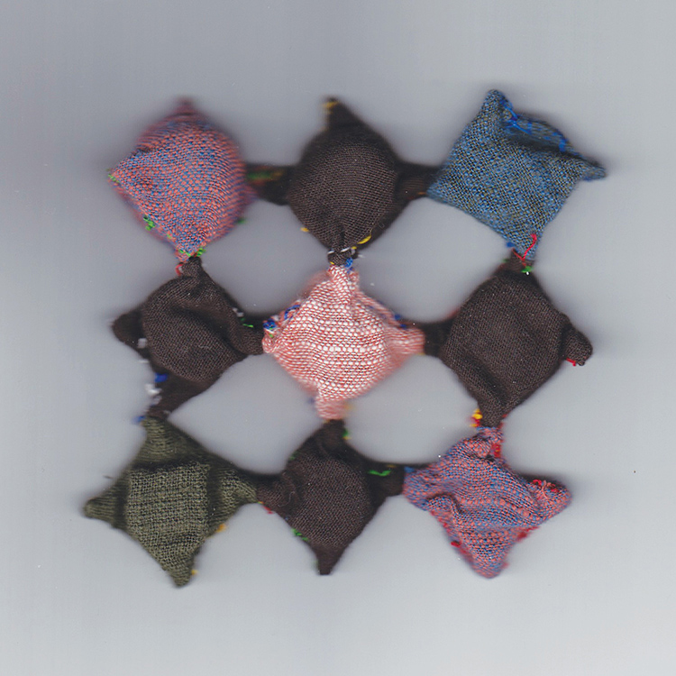 square of 9 fabric diamonds in mostly browns and pinks with one blue diamond