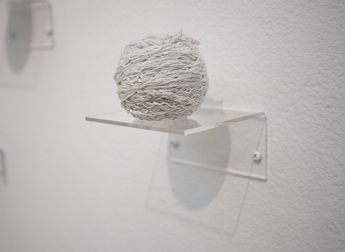 a ball of white yarn on a clear shelf