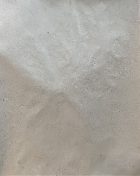 a shadowed piece of paper with the indented impressions of lines visible