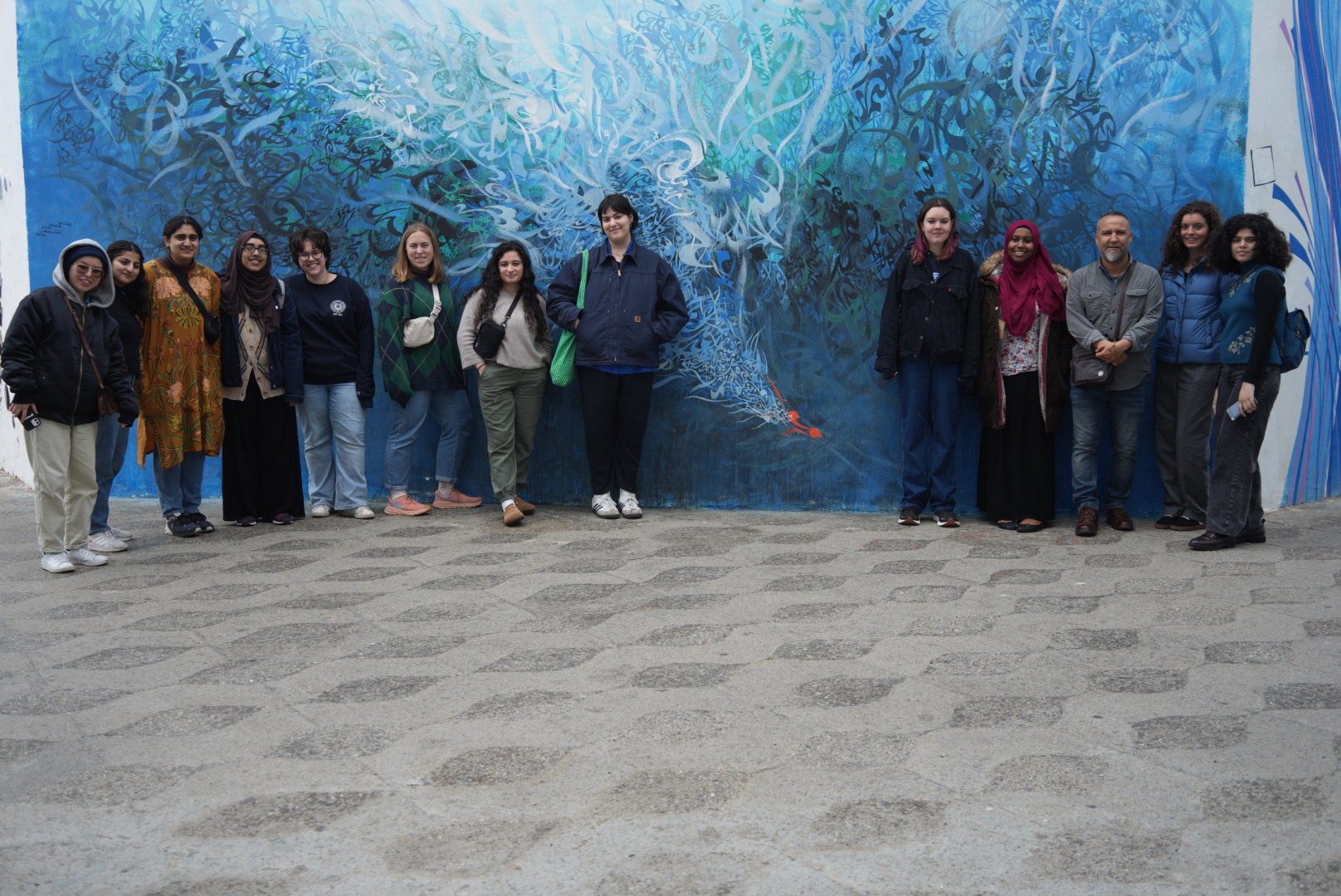 Wintersession Students pictured in front of a mural in Morocco