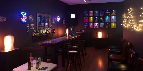 A piece of the exhibit, a replication of a dive bar complete with tables, neon signs and a darts board